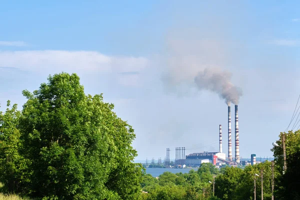 Вугільна електростанція має високі труби з чорним димом, що рухається вгору забруднюючи атмосферу. Виробництво електроенергії з концепцією викопного палива — стокове фото