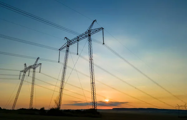Torri ad alta tensione con linee elettriche al tramonto — Foto Stock