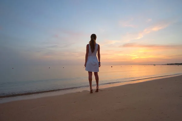 Solitario giovane donna in piedi sulla spiaggia di sabbia dal mare godendo calda serata tropicale — Foto Stock