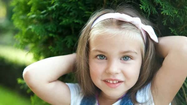 Portret van gelukkig mooi kind meisje staan in de zomer park kijken in camera — Stockfoto