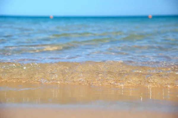 Seascape com superfície de água do mar azul com pequenas ondas onduladas batendo na praia de areia amarela. Conceito de viagem e férias — Fotografia de Stock