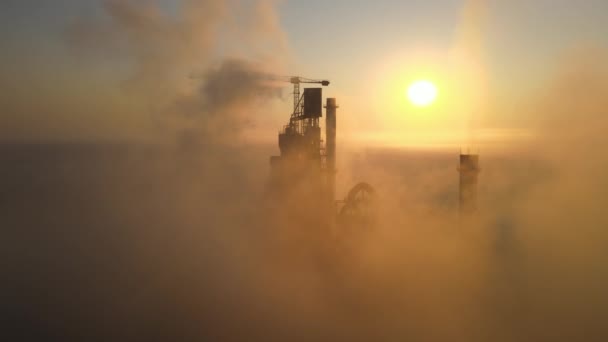 Aerial view of cement factory with high concrete plant structure and tower crane at industrial production site on foggy morning. Manufacture and global industry concept — Stock Video