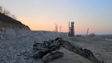 Taş ocağındaki çakıl kaynaklarını kazmak için kazıcı ekipmanlarıyla birlikte inşaat kum taşı malzemelerinden oluşan açık maden sahası