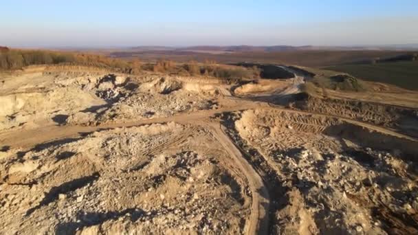 ショベルやダンプトラックと建設業界のための石灰岩材料のオープンピット採掘現場の空中ビュー — ストック動画