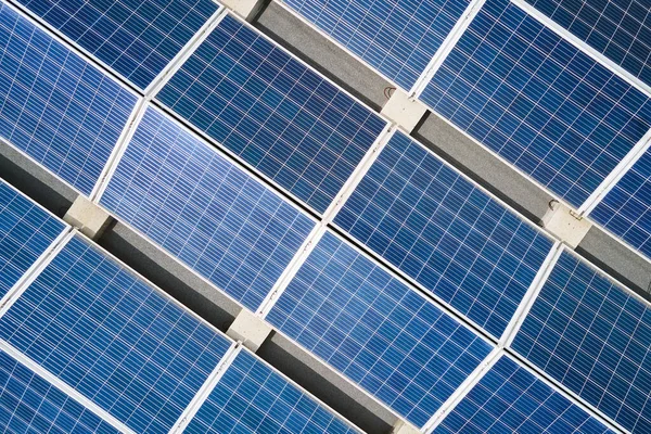 Vue aérienne de panneaux solaires photovoltaïques bleus montés sur le toit d'un bâtiment industriel pour produire de l'électricité écologique verte. Production de concept d'énergie durable — Photo