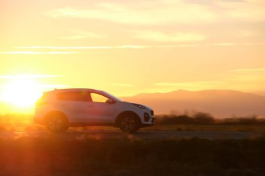 Gün batımında şehir içi yolda hızlı giden bir araba. Akşamları otoyol trafiği