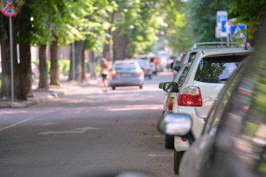 Sokak kenarında park halindeki arabalarla şehir trafiği