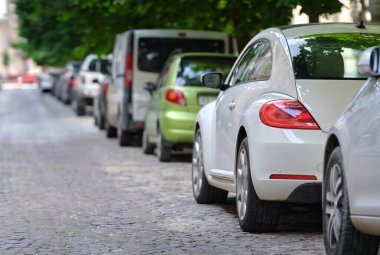 Sokak kenarında park halindeki arabalarla şehir trafiği