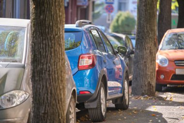 Sokak kenarında park halinde bir sürü araba olan şehir trafiği.