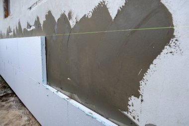 Termal koruma için ev cephesi duvarına köpük yalıtım çarşafları kurulumu