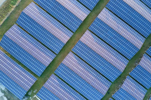 Vista aérea de uma grande usina elétrica sustentável com fileiras de painéis solares fotovoltaicos para a produção de energia elétrica ecológica limpa. Eletricidade renovável com conceito de emissão zero. — Fotografia de Stock