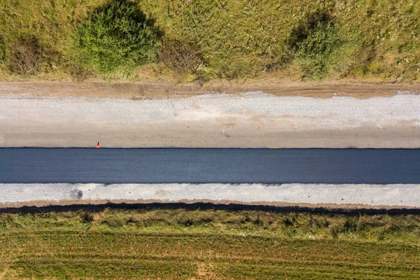 Luchtfoto van nieuwe wegenbouw met nieuw aangelegde zwarte asfaltweg — Stockfoto