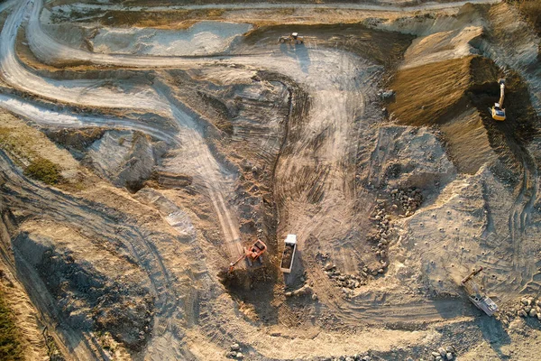 Vista aérea da mina a céu aberto de materiais de arenito para a indústria da construção com escavadoras e caminhões basculantes. Equipamento pesado na mineração e produção de conceito de minerais úteis — Fotografia de Stock