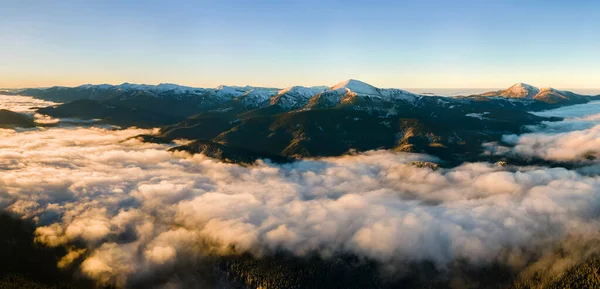 在白色浓雾之上，地平线上遥远的黑暗喀尔巴阡山脉，空中看到了充满活力的日出 — 图库照片