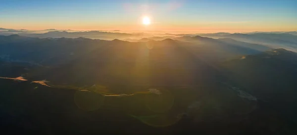 Bela paisagem panorâmica da montanha com picos nebulosos e vale nebuloso ao pôr do sol — Fotografia de Stock