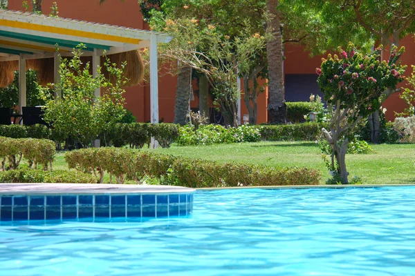 열 대의 휴양지에 있는 수영장에 작은 물결 이 일면서 맑고 푸른 물 이 파도처럼 밀려오고 있다. 여름 방학 개념 — 스톡 사진