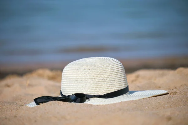 Primer plano del sombrero de paja amarillo en la playa de arena en la costa tropical en un día cálido y soleado. Concepto vacaciones de verano —  Fotos de Stock