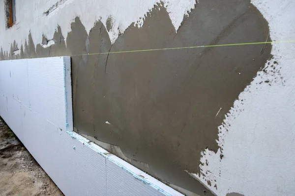 Termal koruma için ev cephesi duvarına köpük yalıtım çarşafları kurulumu