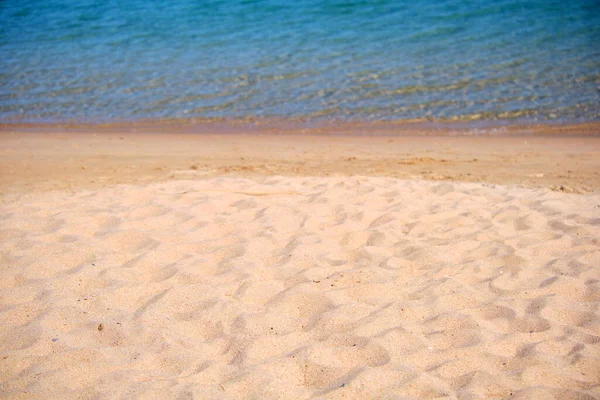 Seascape with surface of blue sea water with small ripple waves crashing on yellow sandy beach. Travel and vacations concept — Stock Photo, Image