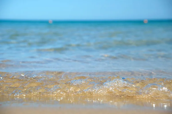 Seascape s povrchem modré mořské vody s malými vlnitými vlnami narážející na žlutou písečnou pláž. Koncept cestování a dovolené — Stock fotografie