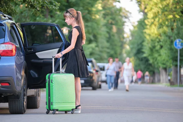 Junge Fahrerin holt Koffertasche aus Auto Reise- und Urlaubskonzept — Stockfoto