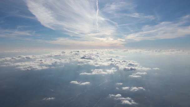 Flygfoto från flygplansfönstret på hög höjd över fjärran stad täckt med lager av tunn dimmig smog och avlägsna moln — Stockvideo