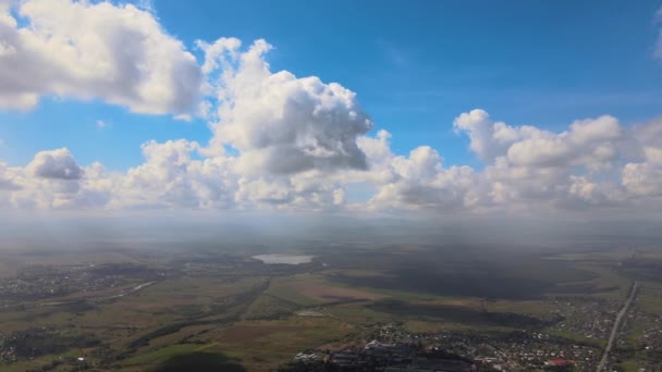 Vista aérea desde la gran altitud de la ciudad distante cubierta de nubes de cúmulos hinchados que se forman antes de la tormenta — Vídeo de stock