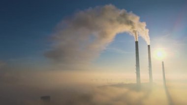 Kara dumanlı yüksek borular güneş doğarken atmosferi kirletiyor.