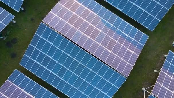 Temiz ekolojik elektrik enerjisi üretmek için sıra sıra güneş fotovoltaik panelleri olan sürdürülebilir büyük elektrik santralinin havadan görünüşü. Sıfır emisyon kavramı ile yenilenebilir elektrik. — Stok video