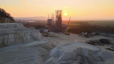 Çimento fabrikası inşaat için kum taşı malzemelerinin açık madenciliğinde. Gün batımında taş ocağında çakıl ocağı kazmak.