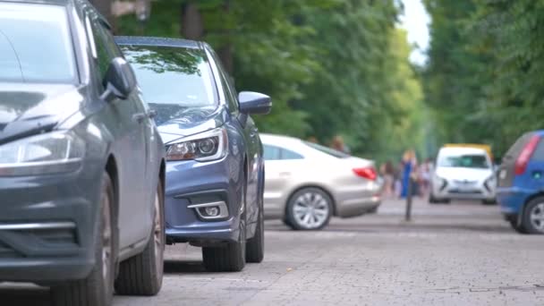 Κυκλοφορία στην πόλη με τα αυτοκίνητα σταθμευμένα στην ουρά στην πλευρά του δρόμου — Αρχείο Βίντεο
