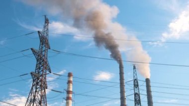 Kömür santraline karşı yüksek voltajlı elektrik direkleri siyah dumanlı yüksek borular atmosferi kirletiyor. Fosil yakıt kavramına sahip elektrik enerjisi üretimi