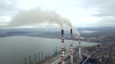 Kömür santralinden gelen gri dumanlı yüksek baca borularının havadan görüntüsü. Fosil yakıtla elektrik üretimi