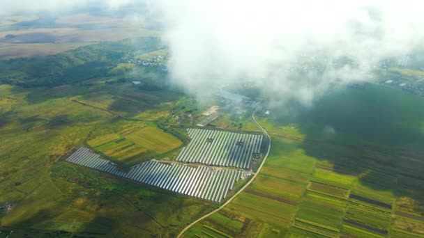 Letecký pohled na velkou udržitelnou elektrárnu s mnoha řadami solárních fotovoltaických panelů pro výrobu čisté ekologické elektrické energie za oblačného počasí bez slunečního svitu — Stock video