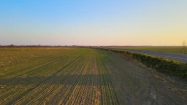 Gün batımında hızlı giden arabalarla şehirlerarası yol manzarası. Akşamları otoban trafiğinin insansız hava aracı görüntüsü