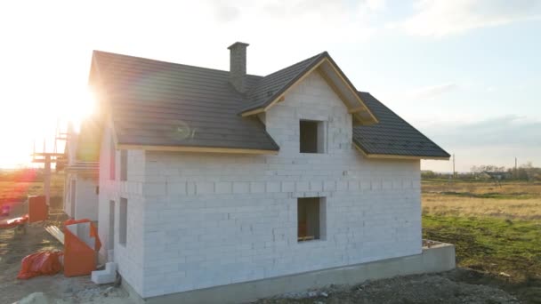 Vue aérienne de la maison inachevée avec murs en béton léger aéré et cadre de toit en bois recouvert de tuiles métalliques en construction — Video