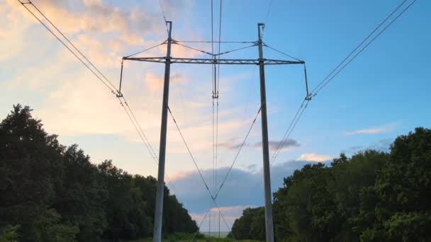 Siluet gelap dari menara tegangan tinggi dengan kabel listrik saat matahari terbenam. Transfer konsep listrik — Stok Video