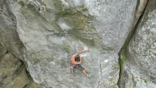 Forte alpinista do sexo masculino escalando parede íngreme de montanha rochosa. Esportista superando rota difícil. Envolvendo-se em conceito de passatempo esportivo extremo — Vídeo de Stock