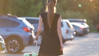 Genç bayan sürücü bagajını arabasına koyuyor. Seyahat ve tatil kavramı