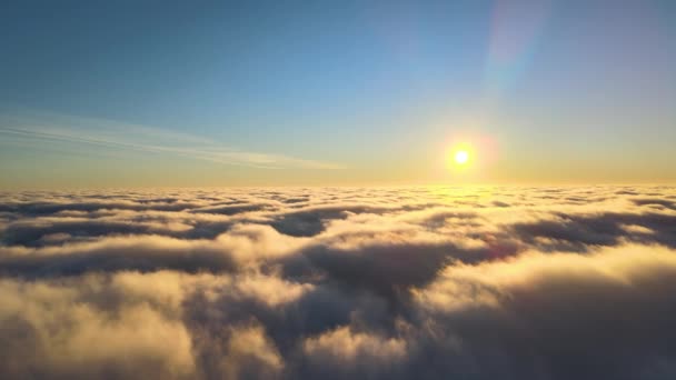 Vue aérienne d'en haut, à haute altitude, de nuages cumulus denses et bouffis volant en soirée. Coucher de soleil incroyable du point de vue de la fenêtre de l'avion — Video