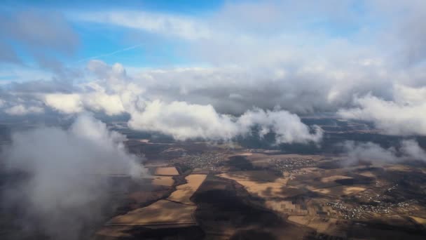 Luftaufnahme aus der Höhe einer weit entfernten Stadt, die vor dem Regensturm von aufgedunsenen Kumuluswolken bedeckt war. Flugzeugbild der Landschaft bei bewölktem Wetter — Stockvideo