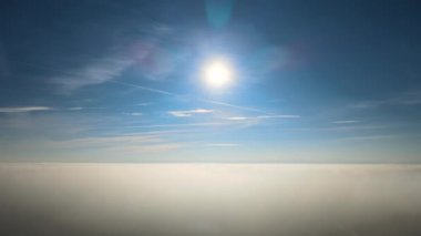 Güneşli bir günde, yeryüzünün yüksek irtifasından beyaz kabarık kümülüs bulutlarıyla kaplı hava manzarası.