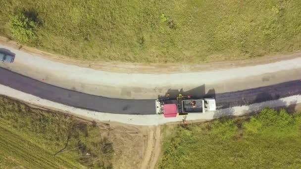 Vista aérea de la nueva construcción de carreteras con trabajadores y maquinaria de asfalto en el trabajo — Vídeo de stock