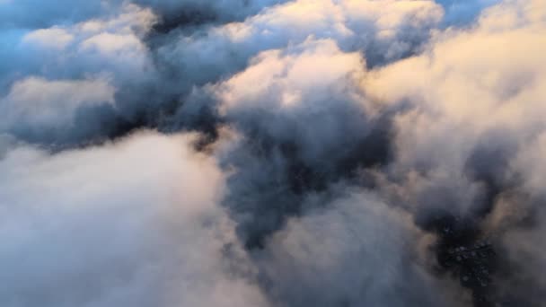 Vista aérea desde la gran altitud de la ciudad distante cubierta de nubes de cúmulos hinchados que pasan volando antes de la tormenta al atardecer. Avión punto de vista del paisaje en tiempo nublado — Vídeos de Stock