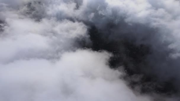 Vista aérea desde gran altitud de la ciudad distante cubierta de nubes de cúmulos hinchados que se forman antes de la tormenta. Punto de vista del avión del paisaje nublado — Vídeos de Stock
