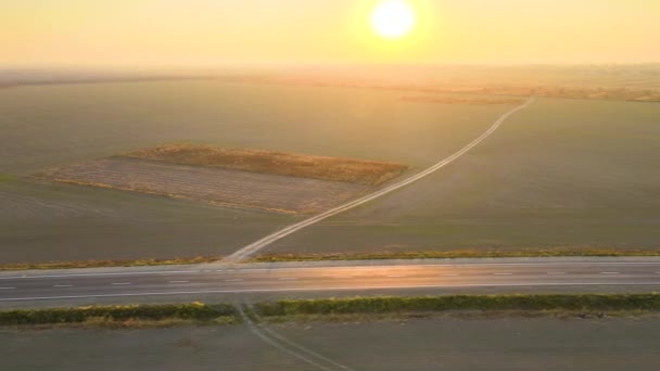 Vue aérienne de la route interurbaine avec voiture à conduite rapide au coucher du soleil. Vue de dessus du drone de la circulation routière en soirée — Video