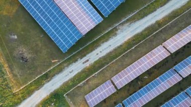 Temiz ekolojik elektrik enerjisi üretmek için sıra sıra güneş fotovoltaik panelleri olan sürdürülebilir büyük elektrik santralinin havadan görünüşü. Sıfır emisyon kavramı ile yenilenebilir elektrik.