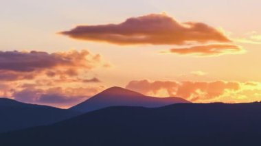 Güzel bir akşam panoramik manzarası. Gün batımında uzak dağ tepeleri üzerinde parlak batan güneş.