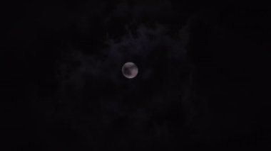 Gece gökyüzünde hızla hareket eden parlak dolunay.