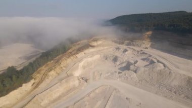 Kazı araçları ve çöp kamyonlarıyla inşaat endüstrisi için kireçtaşı malzemelerinin açık maden sahası görüntüsü